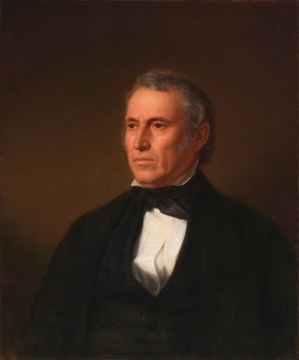 an old man in a black suit and bow tie