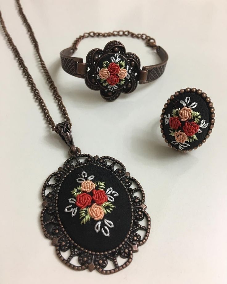 three pieces of jewelry sitting on top of a table