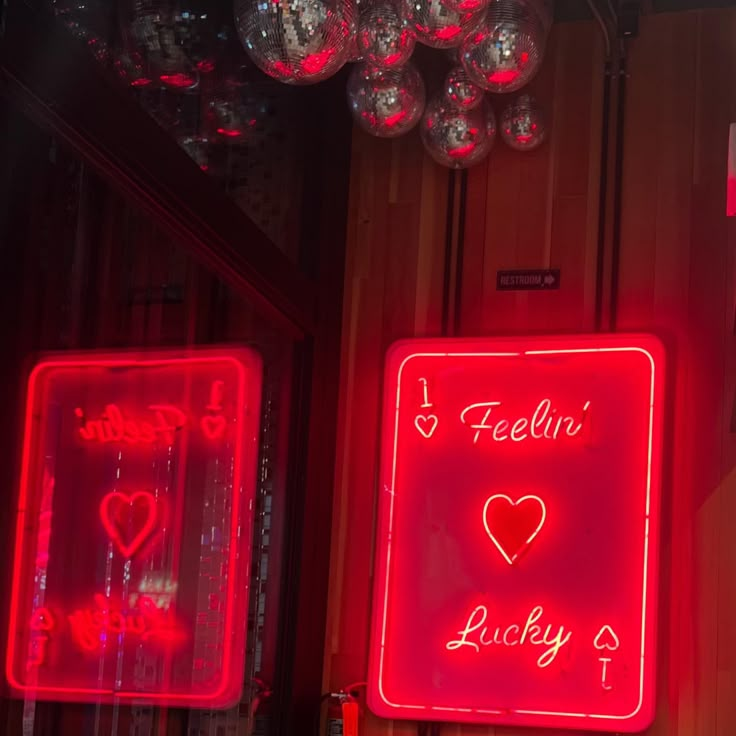 two neon signs are hanging on the wall