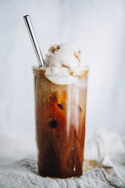 an iced drink with whipped cream and caramel on the top is sitting on a white cloth