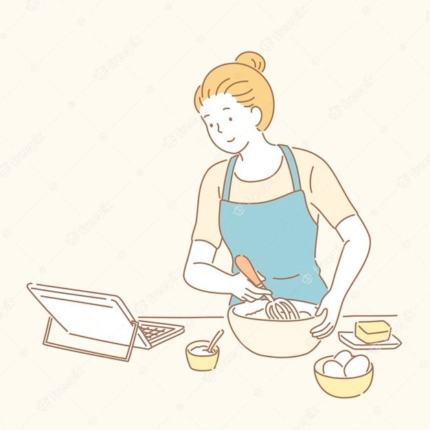 a woman in an apron mixing food on a table with a laptop and other items