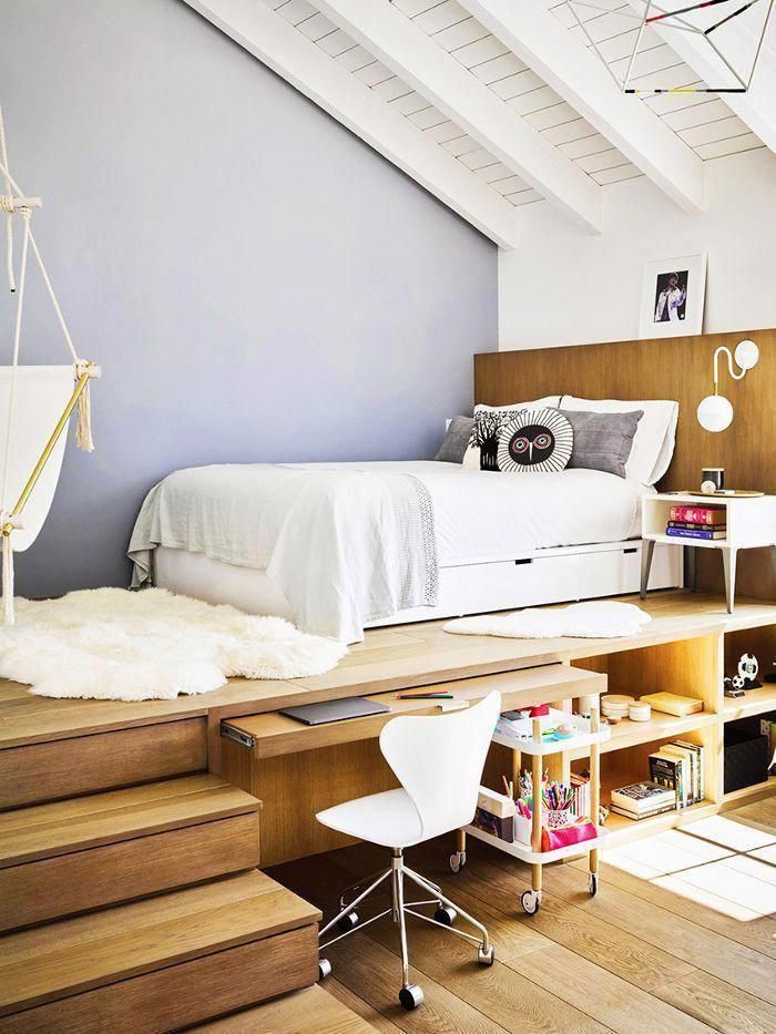 a bedroom with stairs leading up to the bed and desks in front of it