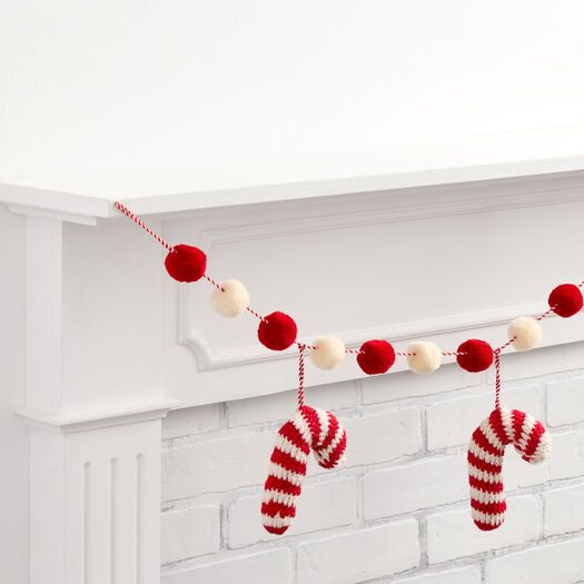 christmas stockings hanging from a mantle with pom - poms