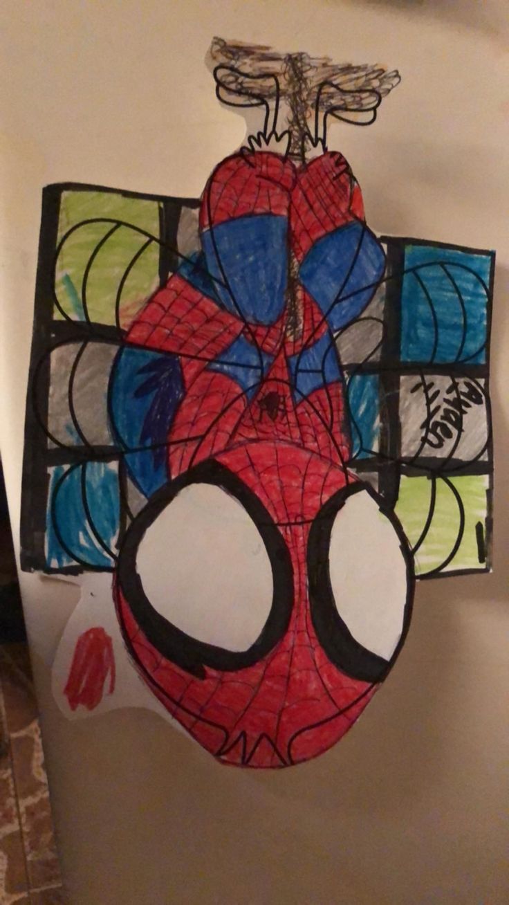 a spiderman mask hanging from the ceiling in a room with other art work on it