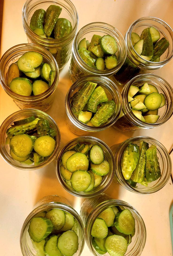 several jars filled with pickles sitting on top of a table