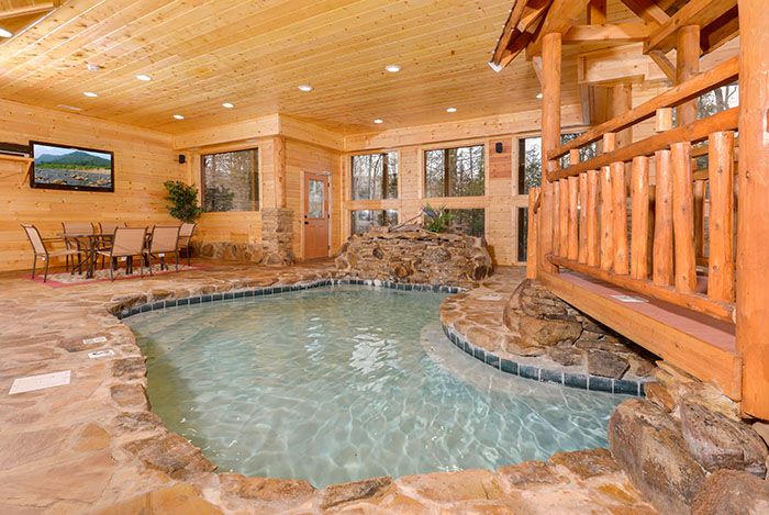 an indoor hot tub in the middle of a room with wood walls and flooring