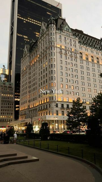 the building is lit up at night in front of other buildings