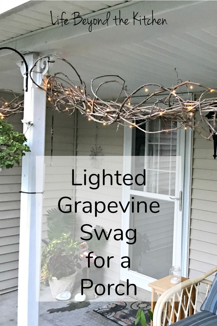 the front porch is decorated with lights and grapevine swag for a porch decoration