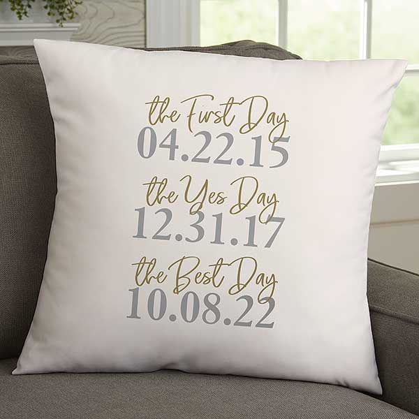 a white pillow with the date and time printed on it, sitting on a couch