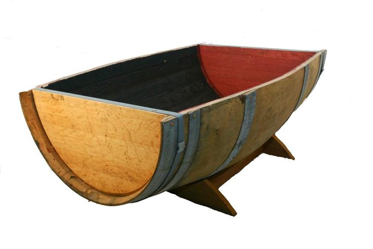 a wooden barrel shaped like a boat with black and red paint on the bottom, sitting on a stand