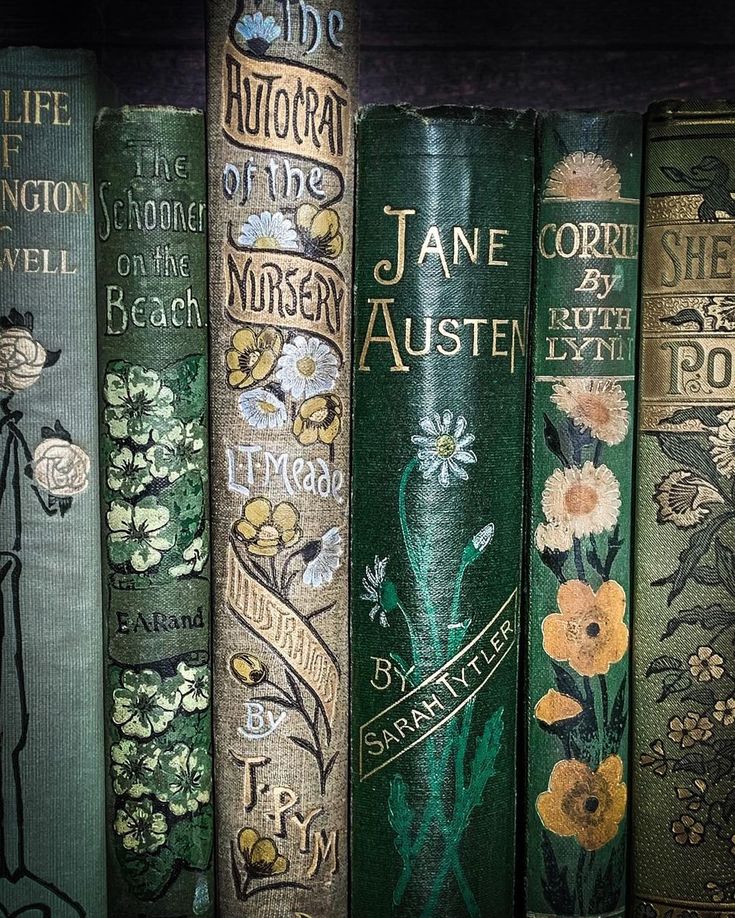 several books are lined up on a shelf in a row with flowers painted on them