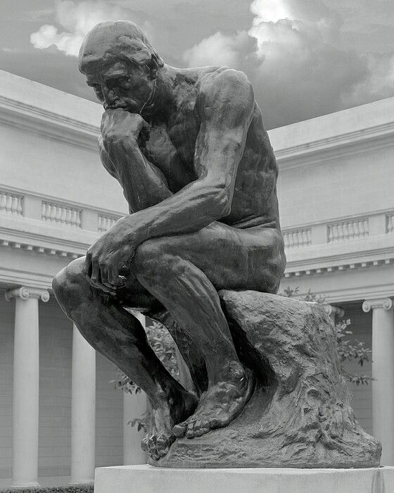 a black and white photo of a statue of a man with his head in his hands