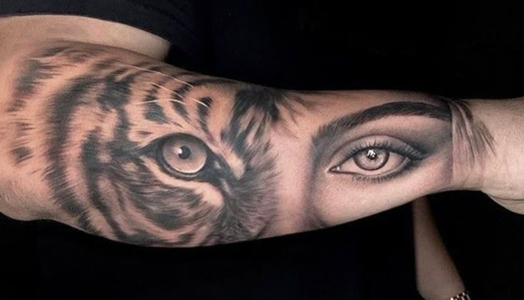 a man's arm with a tiger tattoo on it and an eye in the middle