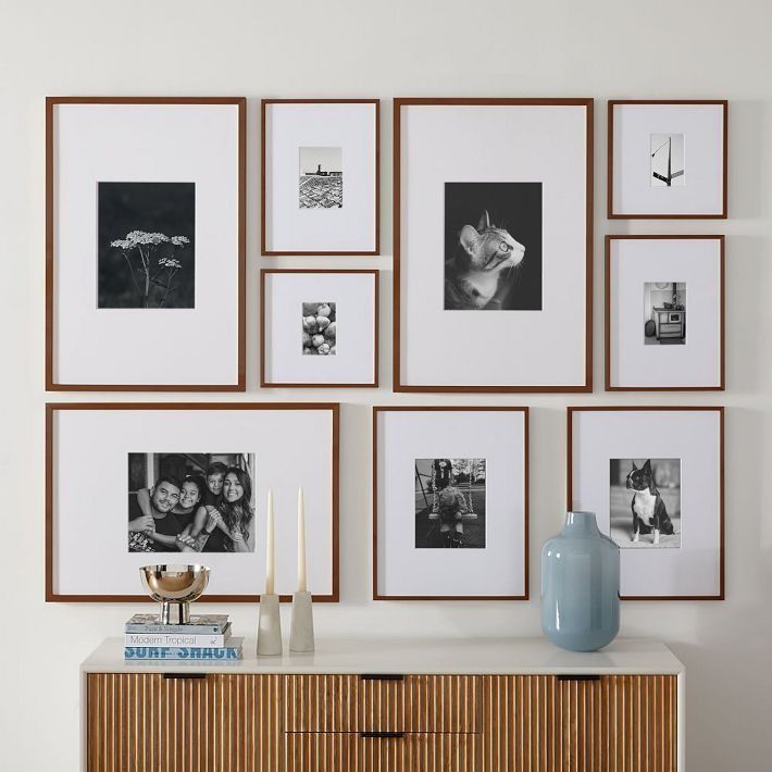 a wall with many framed pictures on it