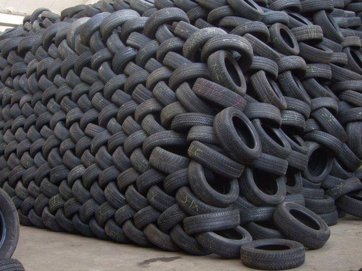 a pile of tires sitting next to each other on top of a cement floor in front of a building