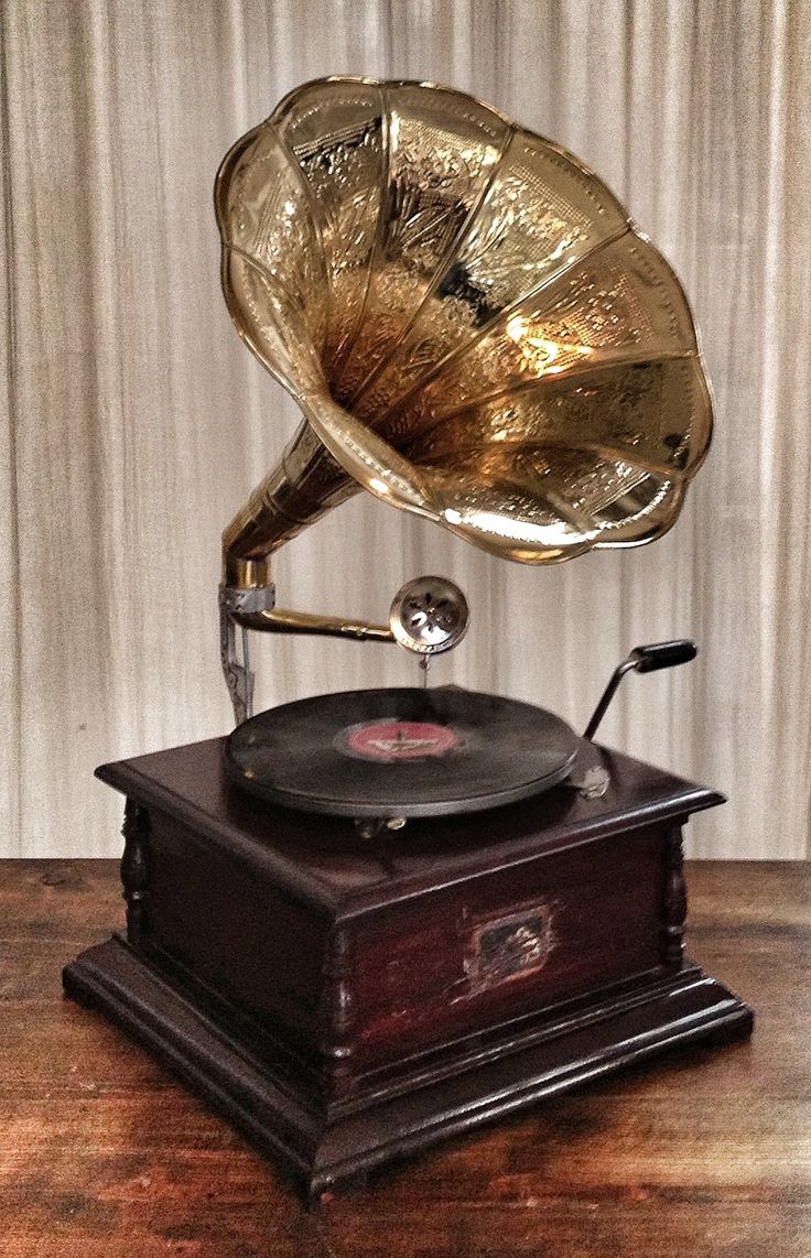 an old fashioned record player sitting on top of a wooden table