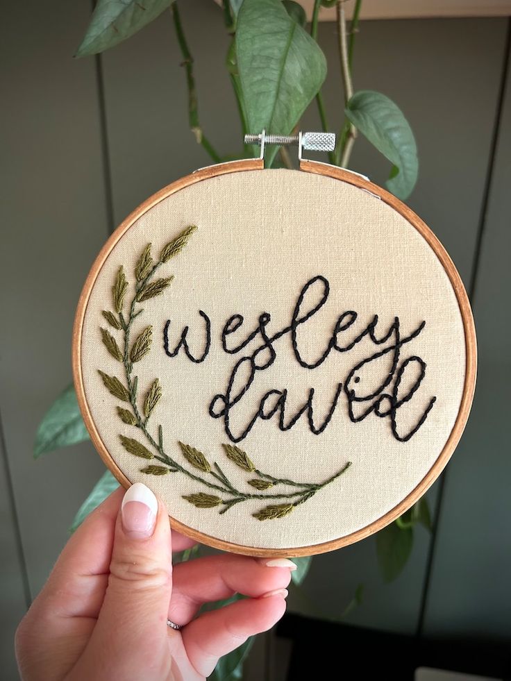 a person holding up a small embroidered hoop