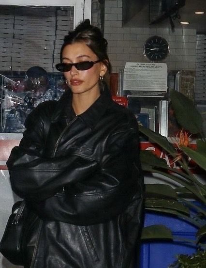 a woman in black leather jacket and sunglasses