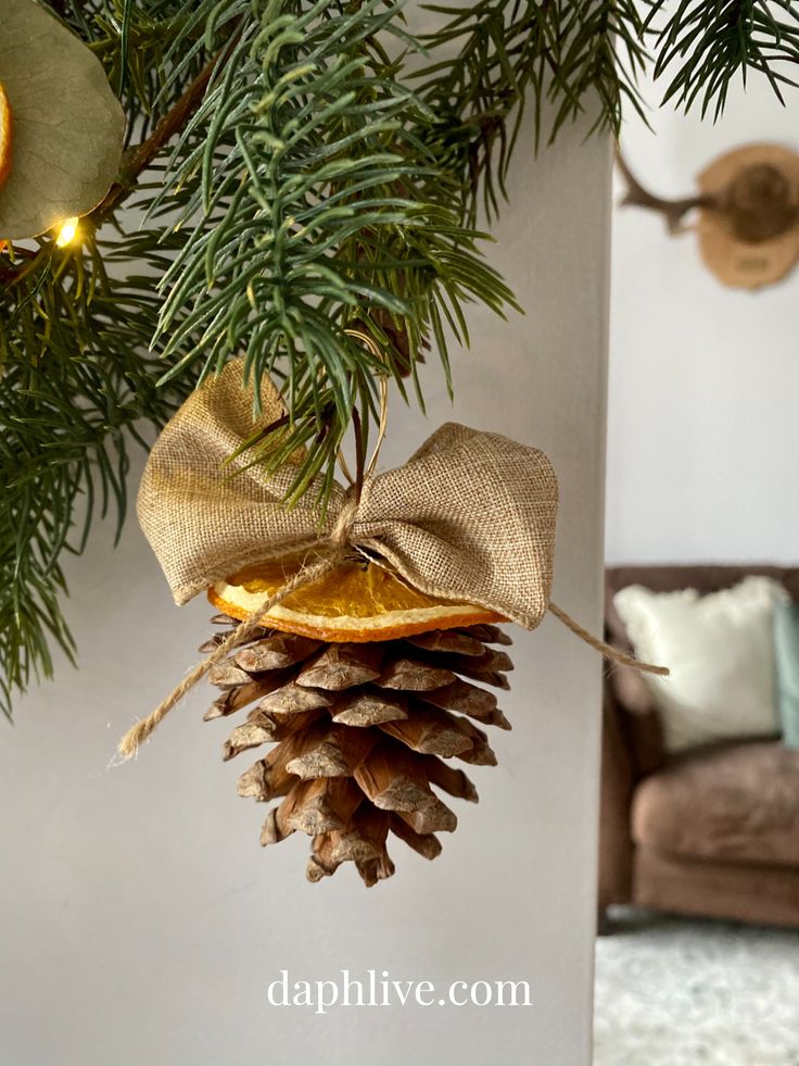 a pine cone ornament hanging from a christmas tree