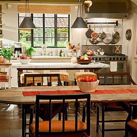 a kitchen filled with lots of counter top space and wooden chairs next to a dining room table