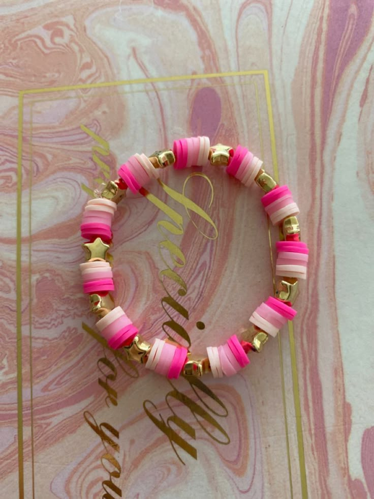 two pink and gold bracelets sitting on top of a marble surface with the word monogram