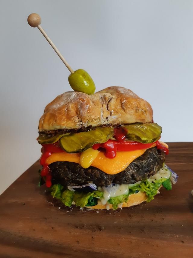 a cheeseburger with pickles, peppers and onions