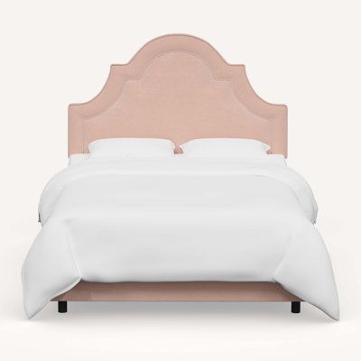 a bed with a pink headboard and white sheets on it's sides, in front of a light gray background