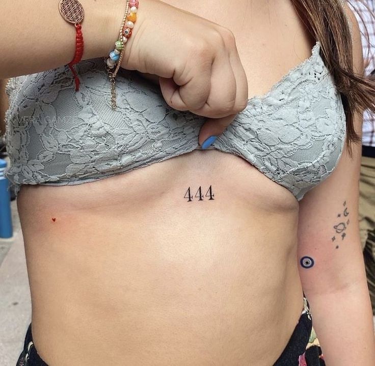 a woman with a tattoo on her stomach and the number forty four behind her belly