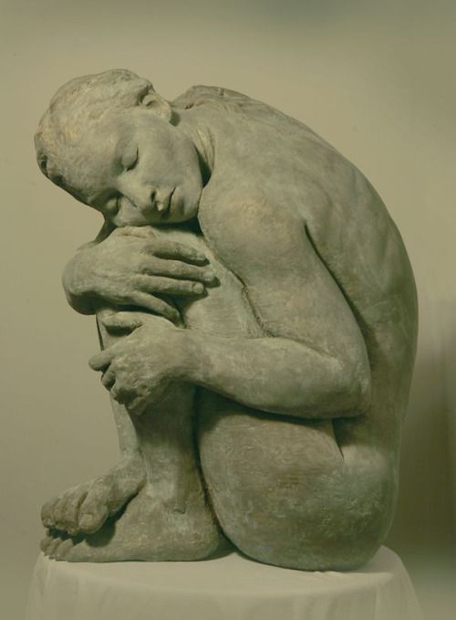 a sculpture of a man holding his head in his hands