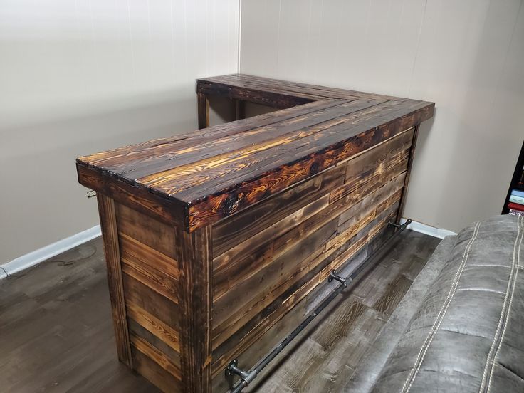 a large wooden box sitting on top of a hard wood floor next to a wall