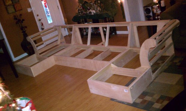 a white bench sitting on top of a hard wood floor next to a christmas tree