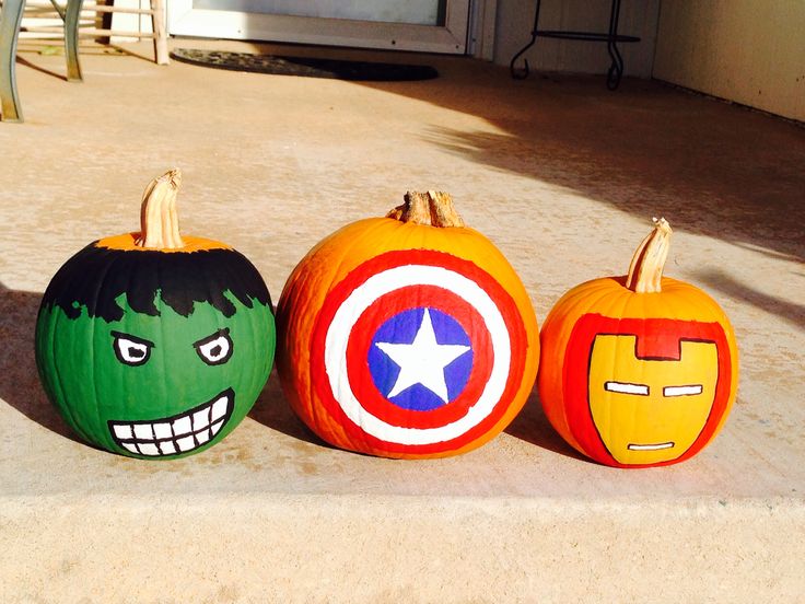 three pumpkins painted to look like the avengers and captain america characters are sitting on concrete