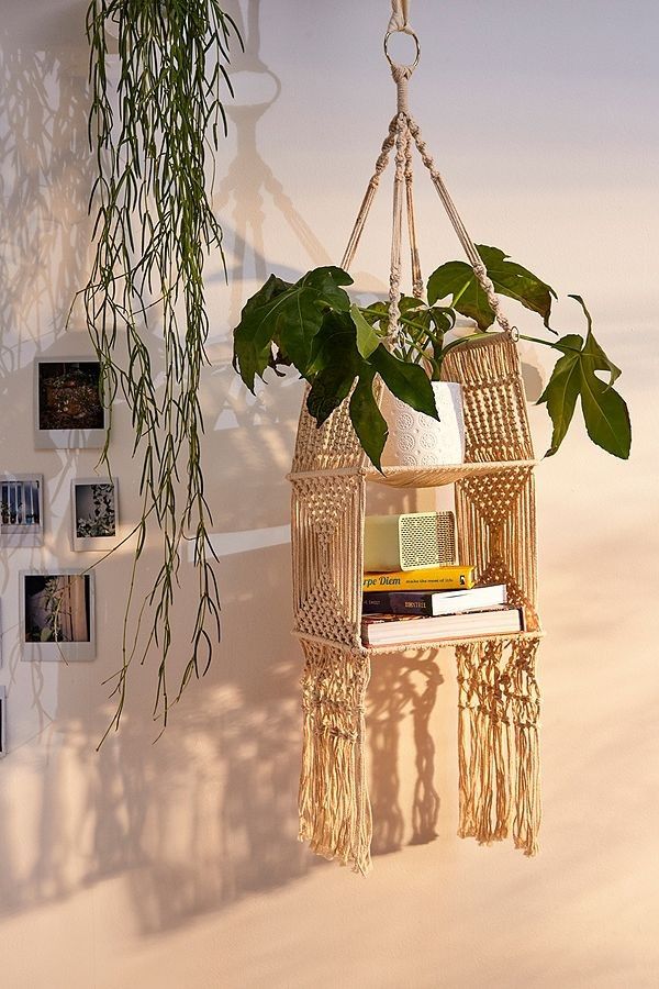 a hanging planter with books and plants in it