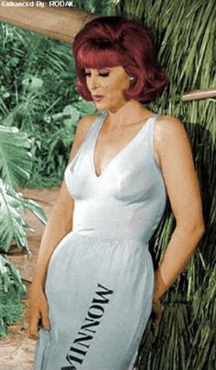 a woman with red hair is standing in front of some plants and trees, wearing a dress that says marilyn monroe