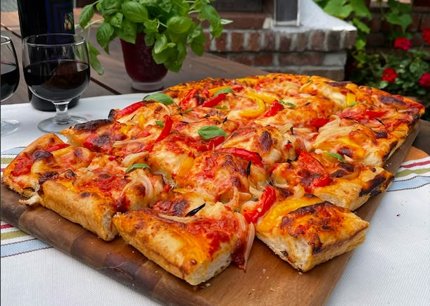 a large pizza sitting on top of a wooden cutting board