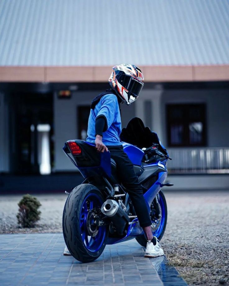 a man sitting on top of a blue motorcycle