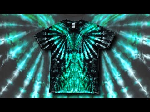 a green and black tie dye t - shirt with an intricate design on the chest