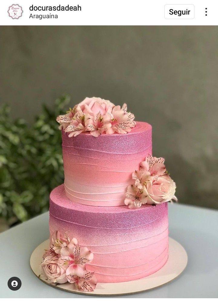 a three tiered cake with pink flowers on top