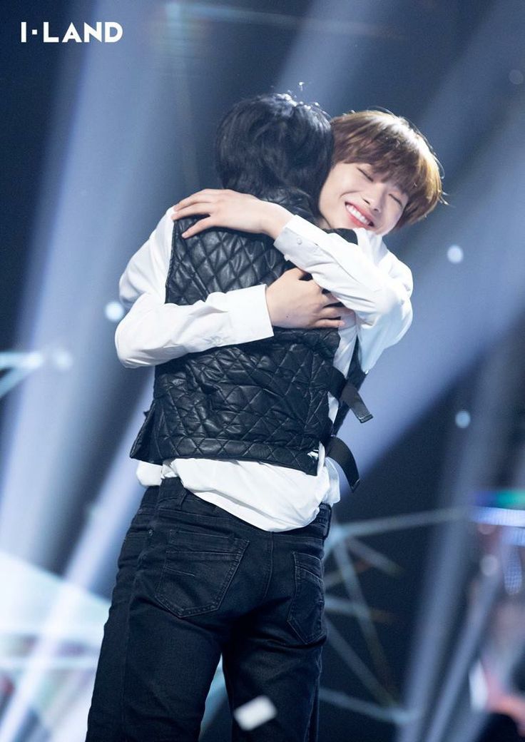 two people hugging each other on stage