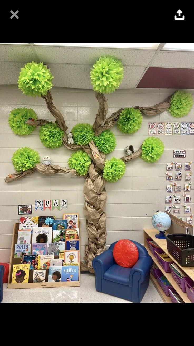 a classroom decorated with green tissue pom poms and a tree on the wall