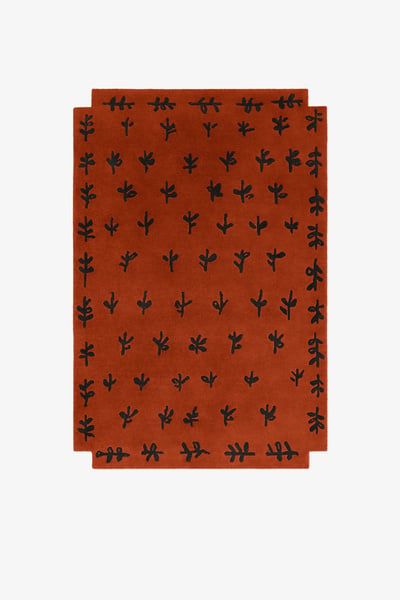 an orange and black rug with small cactus designs on the front, against a white background