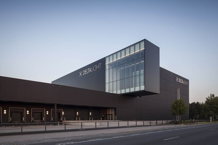 the exterior of a large building with many windows on it's sides and an empty street in front of it