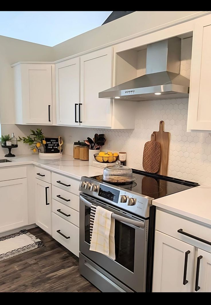 a kitchen with white cabinets and stainless steel appliances