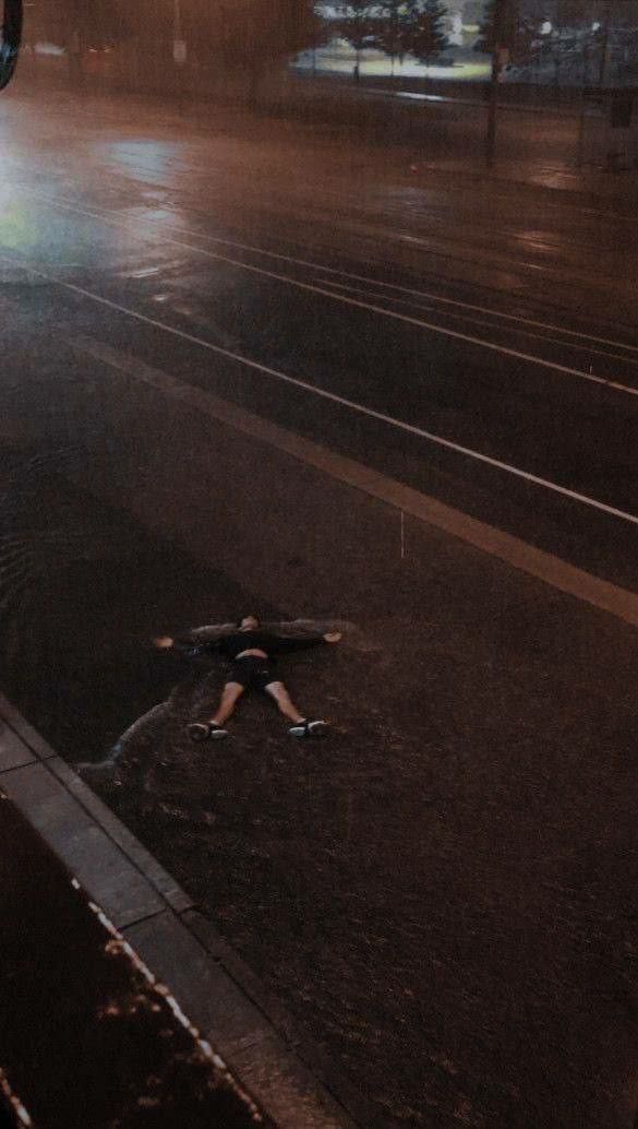 a person laying on the ground in the rain