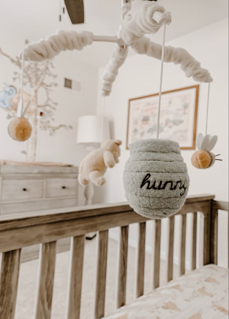 a baby crib with stuffed animals hanging from it's hooks and the word bunny written on them