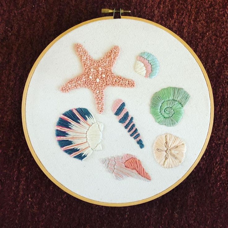 a cross stitch pattern with shells and starfishs on the bottom, in a circular frame