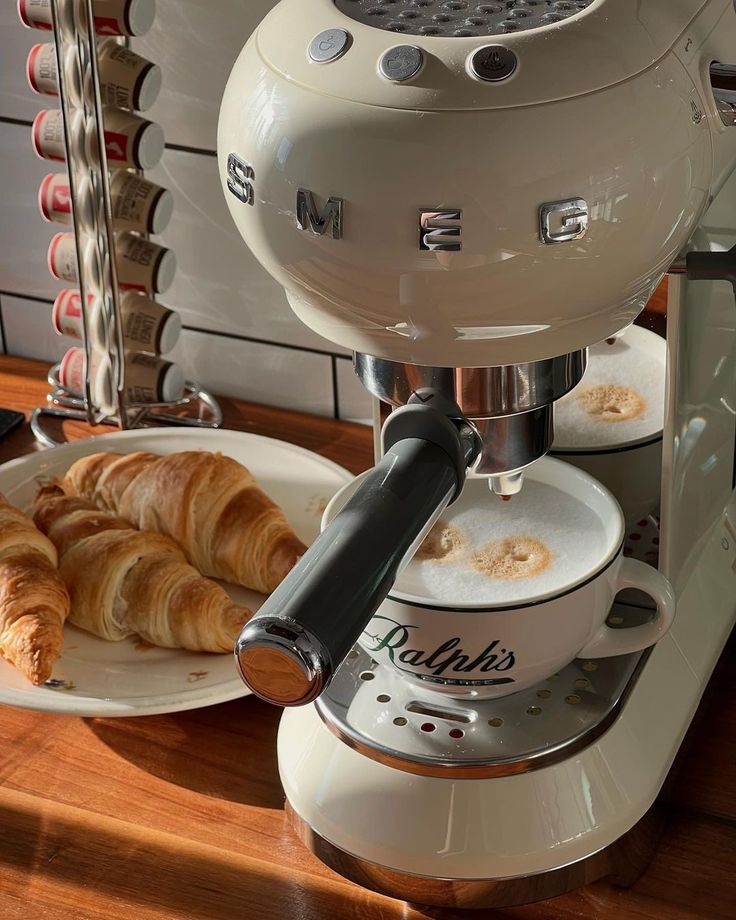 croissants and pastries sit on plates in front of an espresso machine