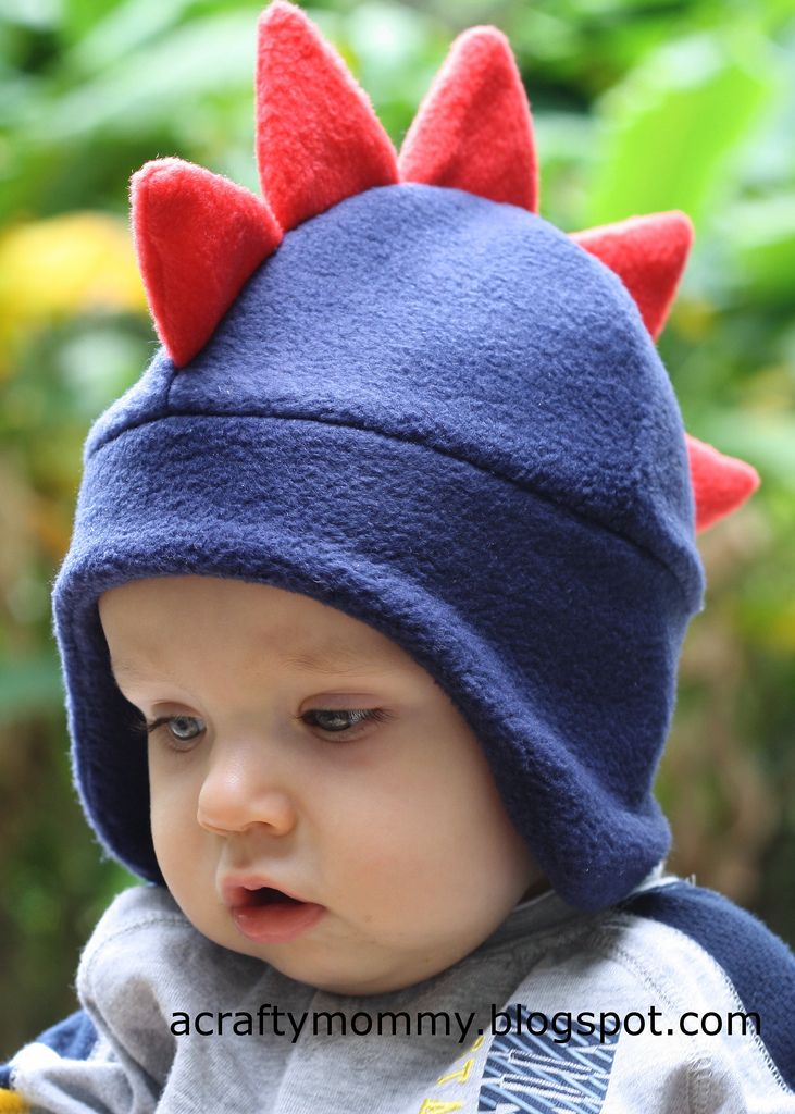 a baby wearing a blue hat with red spikes