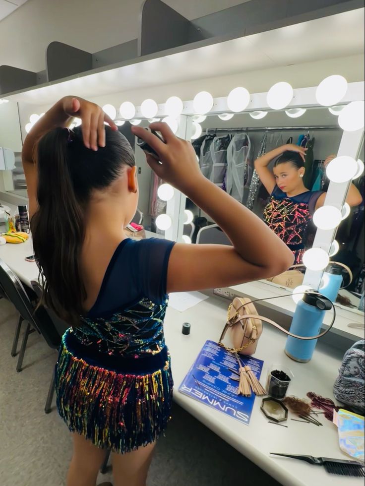 a young woman standing in front of a mirror