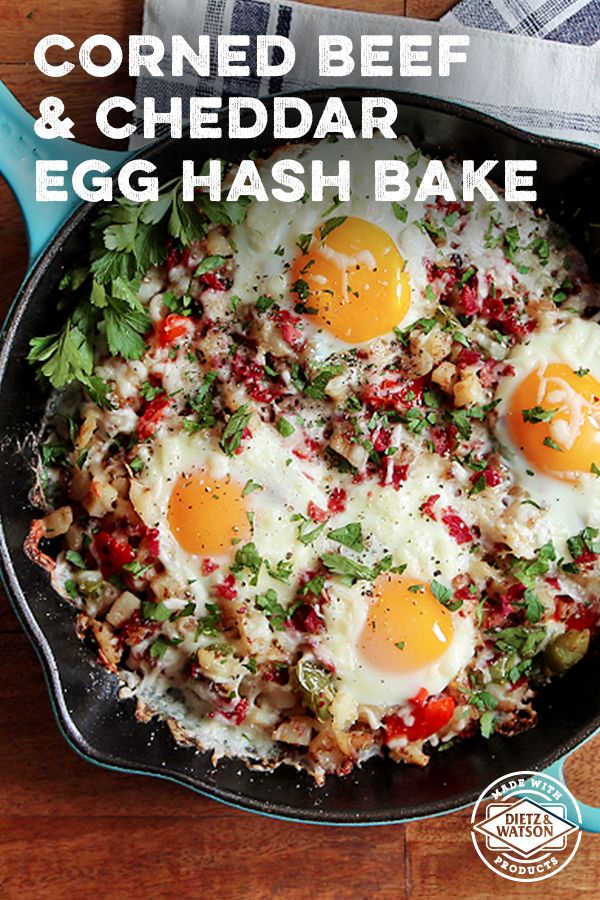 fried beef and cheddar egg hash browns in a cast iron skillet on a wooden table